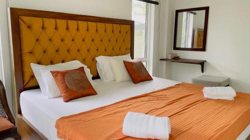 KandanaVilla with a private pool and Garden-Ivory Villa Not for Local的一间卧室配有一张带橙色和白色枕头的大床