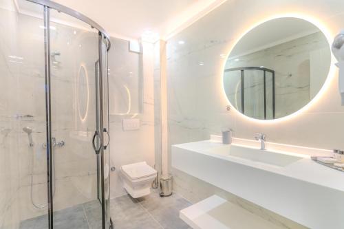 GemlikOlea Suites Gemlik的带淋浴、盥洗盆和镜子的浴室
