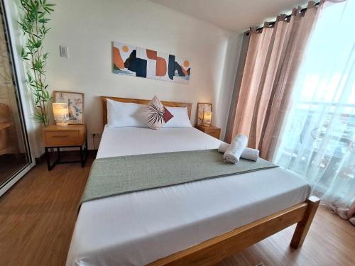 马尼拉Cozy 1BR with City and Nature View in Azure的卧室设有一张白色大床和一扇窗户。