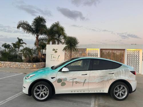 蒂加基TAF Beach Villas with Tesla的停放在停车场的白色小汽车