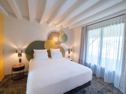 阿普瓦尼Mercure Auxerre Autoroute du Soleil的卧室设有一张白色大床和一扇窗户。