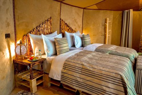梅尔祖卡Sky View Camp的一间卧室配有一张大床和一张边桌