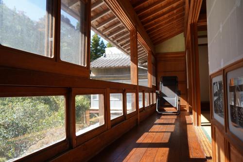 高知TOSAYAMA BASE 清流沿いの里山　古民家貸切　高知市街地より車で約20分的房屋的走廊,设有大窗户