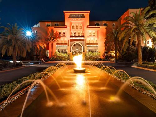 马拉喀什Sofitel Marrakech Palais Impérial & Spa的建筑物前方有喷泉的建筑物