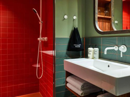 汉堡25hours Hotel Hamburg HafenCity的浴室设有白色水槽和红色瓷砖