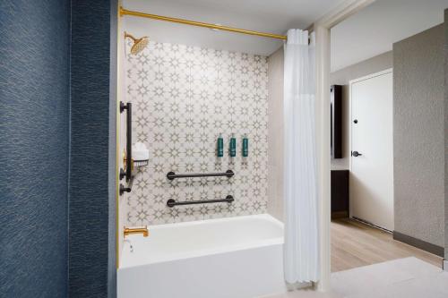 夏洛特DoubleTree by Hilton Charlotte City Center的设有带白色浴缸的淋浴的浴室