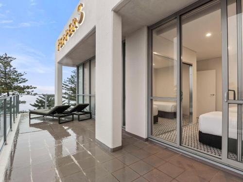 悉尼Peppers Manly Beach的客房设有带一张床的阳台和一间卧室。