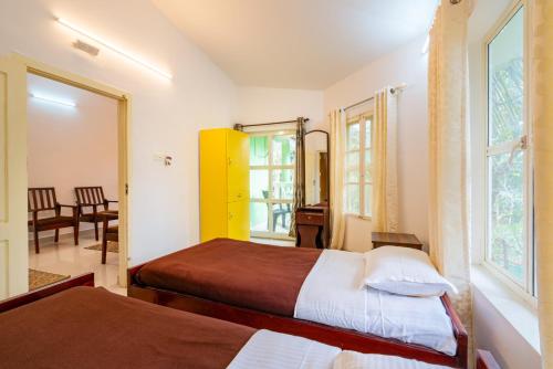 蒙纳Nature Routes Cottage的酒店客房设有两张床和窗户。