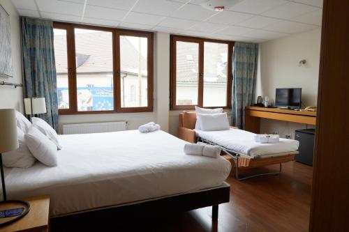 迪沃讷莱班Le Divona的酒店客房配有两张床和一张书桌