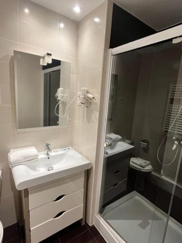 迪沃讷莱班Le Divona的白色的浴室设有水槽和淋浴。