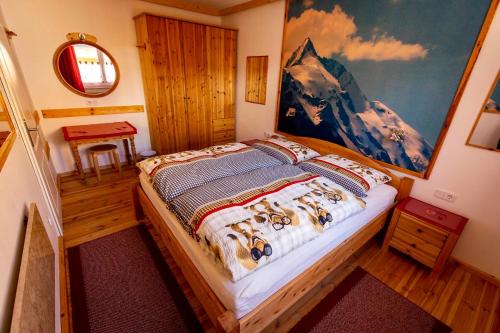 海利根布卢特Chalet Magda的卧室配有一张床,墙上挂有绘画作品