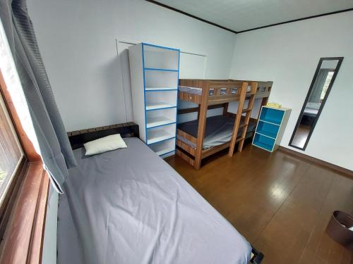 宫崎Finecamp Guesthouse Share Room 相部屋的一间卧室设有一张床和一张双层床。