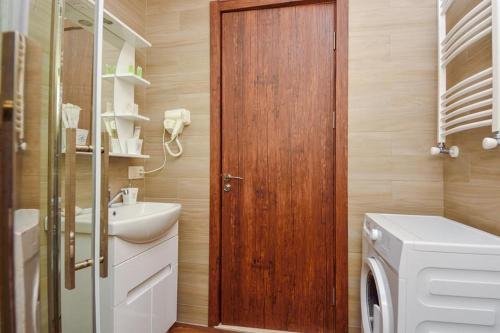 巴库里阿尼Hotel King David Bakuriani的一间带木门和洗衣机的浴室