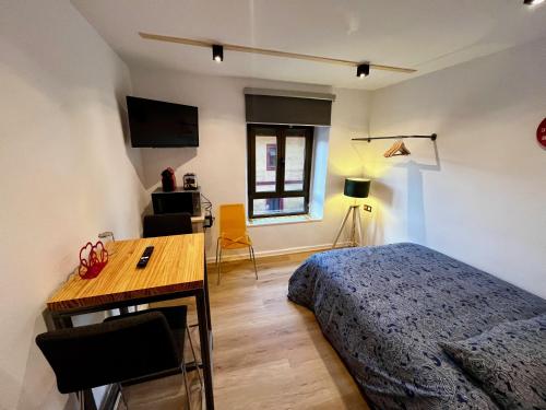 米耶雷斯The Orange Teddy Bear Hostels La Peña的一间卧室配有一张床、一张书桌和一个窗户。