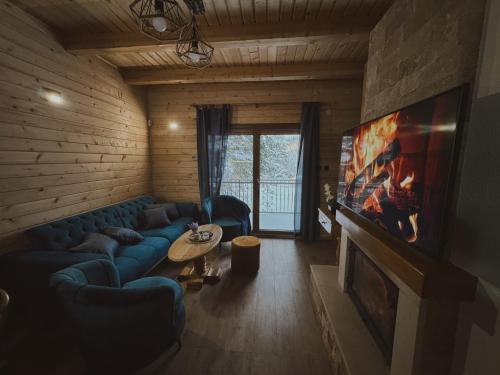 亚霍里纳Planinska kuća Dunja的客厅配有蓝色的沙发和电视