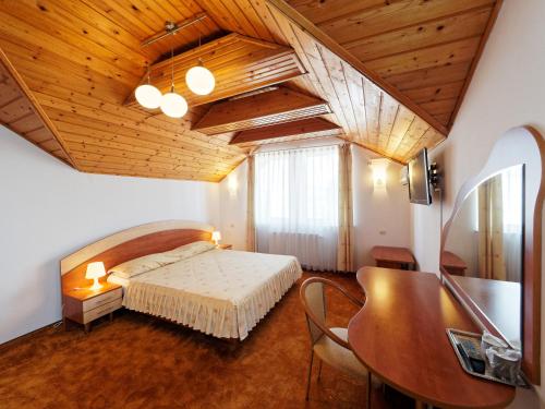 布拉索夫绿洲酒店的一间卧室设有一张床和木制天花板