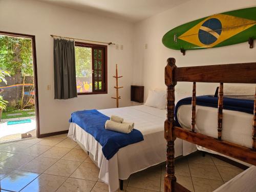 阿布拉奥Raio de Sol pousada & camping的卧室配有一张床,墙上设有冲浪板