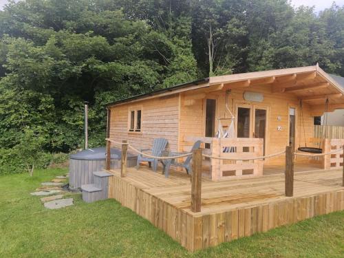 莫维尔Luxury log cabin with wood fired hot tub的小木屋设有甲板和门廊