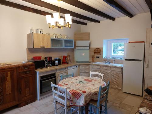 Locoal-Mendonty néo的厨房配有桌椅和冰箱。