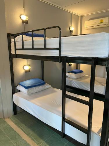 拜县Revolution Pai In Town的配有两张双层床的客房配有白色床单和蓝色枕头