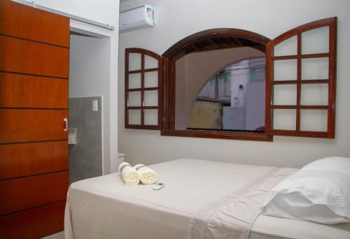 瓦尔任阿Pousada Pôr Do Sol的一间卧室配有一张带镜子的床和两条毛巾