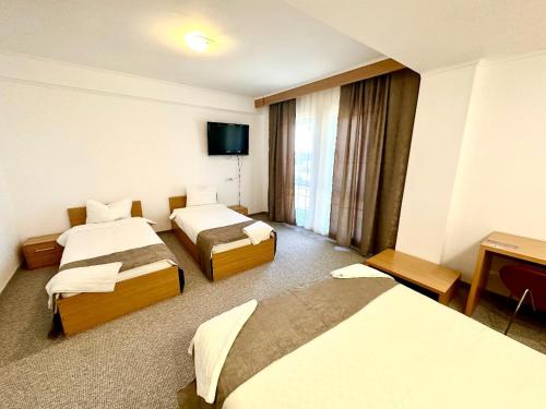 阿拉德Hotel Riga的一间酒店客房,设有三张床和一台平面电视