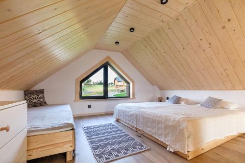 加沃尔金卡Olecka Village的一间卧室设有一张大床和一个窗户。