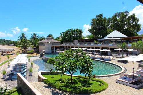 Ambondrona棕榈滩度假村及Spa的一个带遮阳伞的度假游泳池和一个度假村