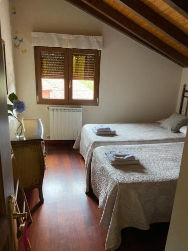 考恩El llagar de Mestas De Con的一间卧室设有两张床和窗户。