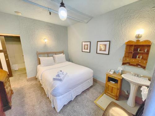 朱诺阿拉斯加酒店及酒吧的卧室配有白色的床和水槽
