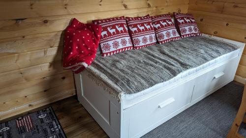 Vittangi KapellLapland Snow Moose的小屋内的一张床位,上面有红色枕头