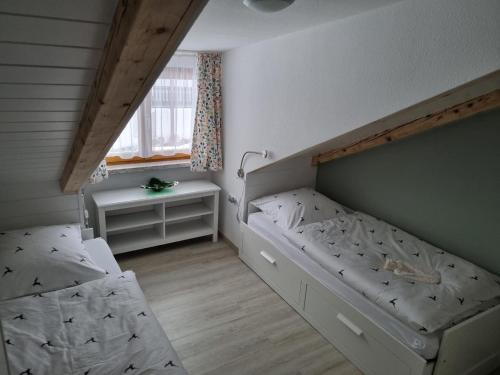 拜尔里舍艾森施泰恩Haus Kuchler的一间小卧室,配有两张床和窗户