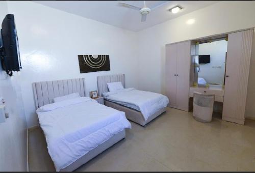 欧拉استراحة الضبيانية的酒店客房设有两张床和电视。