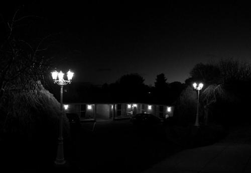 阿米代尔白灯笼汽车旅馆的夜间房子前面有两盏路灯