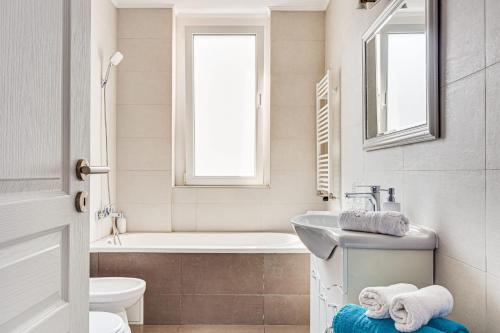 阿拉德Dodi Blue Apartament的一间带水槽、浴缸和卫生间的浴室