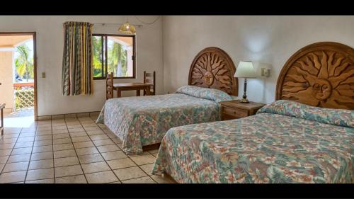 罗斯巴利勒斯Los Barriles Hotel的酒店客房设有两张床和窗户。