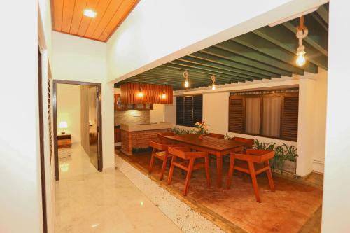 Gonapinuwala WestThisath Villa的厨房以及带木桌和椅子的用餐室。