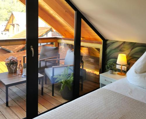韦尼格罗德DAS Chalet mit Schlossblick in Wernigerode的客房设有带一张床和一张桌子的阳台。