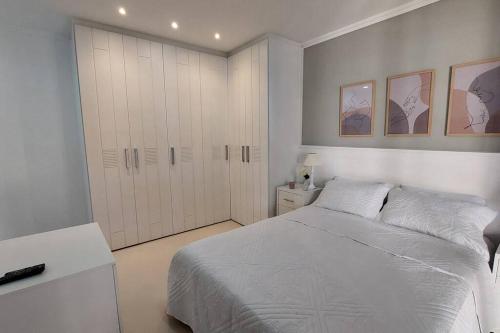 里约热内卢Apartamento aconchegante.的一间白色卧室,配有一张床和一个衣柜
