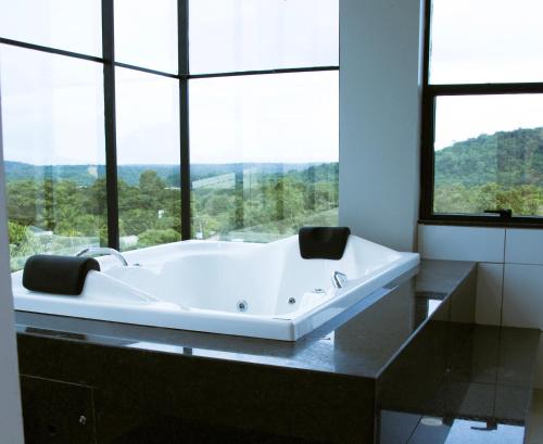 阿尔特杜尚HOTEL TERRA NATIVA的带浴缸的浴室和大窗户