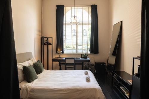 安特卫普Museum Suites的一间卧室配有一张床、一张书桌和一个窗户。