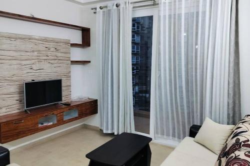 班加罗尔SOLACE Premium 2BHK Apartment near Manyata Tech Park And Hebbal的带沙发、电视和窗户的客厅