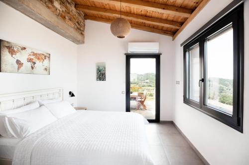 RachesMonopati Eco Villas的卧室设有白色的床和大窗户