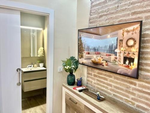 巴塞罗那Front Arc的浴室设有水槽和砖墙上的镜子