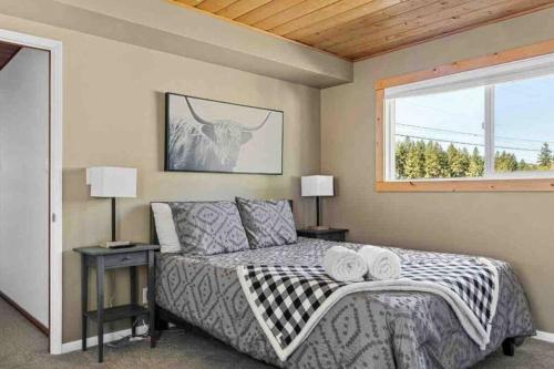 大熊湖Base Camp New Ski Slope Views with HOT TUB.的一间卧室配有一张带两盏灯的床和一扇窗户。