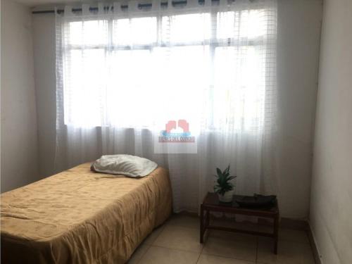 亚美尼亚Casa de Huéspedes en Armenia Quindío, Colombia的一间卧室配有床和带窗帘的窗户