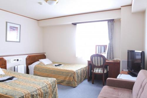 新泻站前艺术酒店的酒店客房设有两张床和电视。
