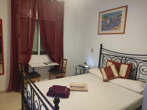 塞维利亚Pino Suite的一间卧室配有一张带红色窗帘的床和一扇窗户