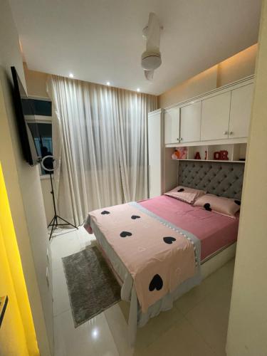 里约热内卢Apartamento Copacabana Luxo的一间卧室配有一张带粉色床单的床和一扇窗户。