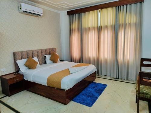 新德里Hotel Soft Petal Residency - Delhi Airport的一间卧室设有一张床和一个大窗户